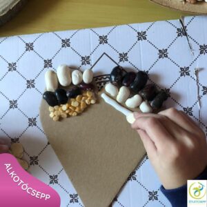 szív formára gyerek kéz magokat pakol a ragasztóba