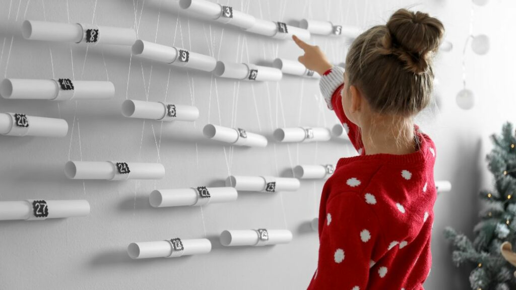 kislány áll 24 fellógatott papírtekercs előtt