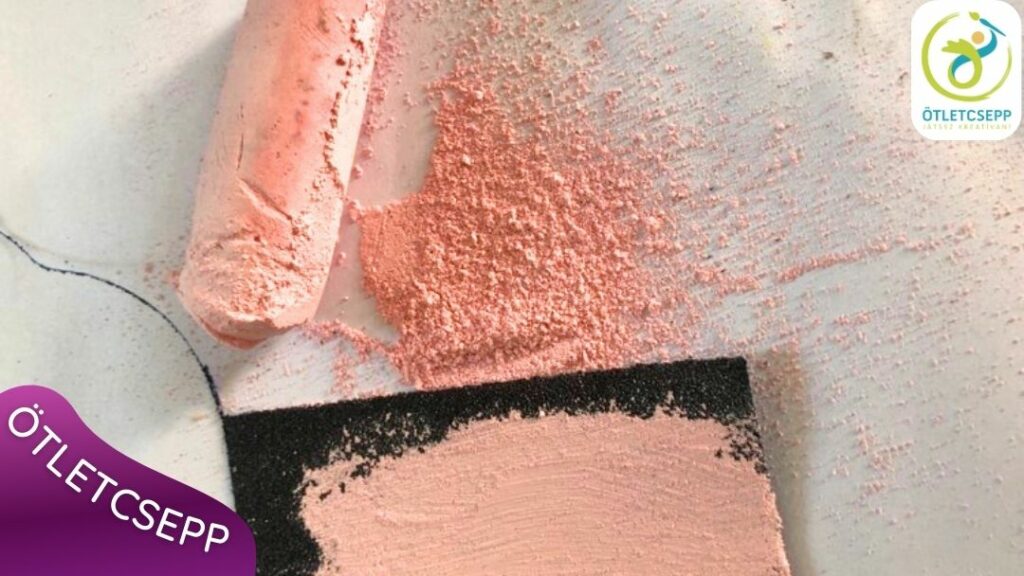 dörzspapíron piros krétanyomok, mellette fehér lapon a kapott krétapor és egy piros aszfaltkréta