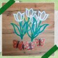 lelaminált fehér filigrán tulipánok az asztalon, alattuk piros filigrn pillangók